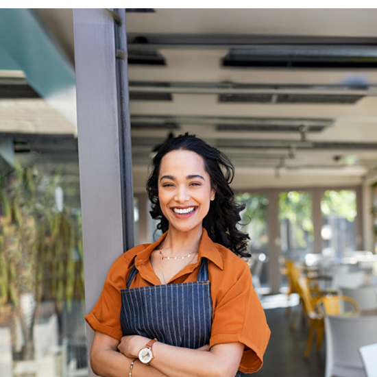 women smiling in front of business entrance