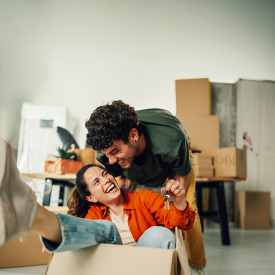 Excited couple holding keys, just bought a new house