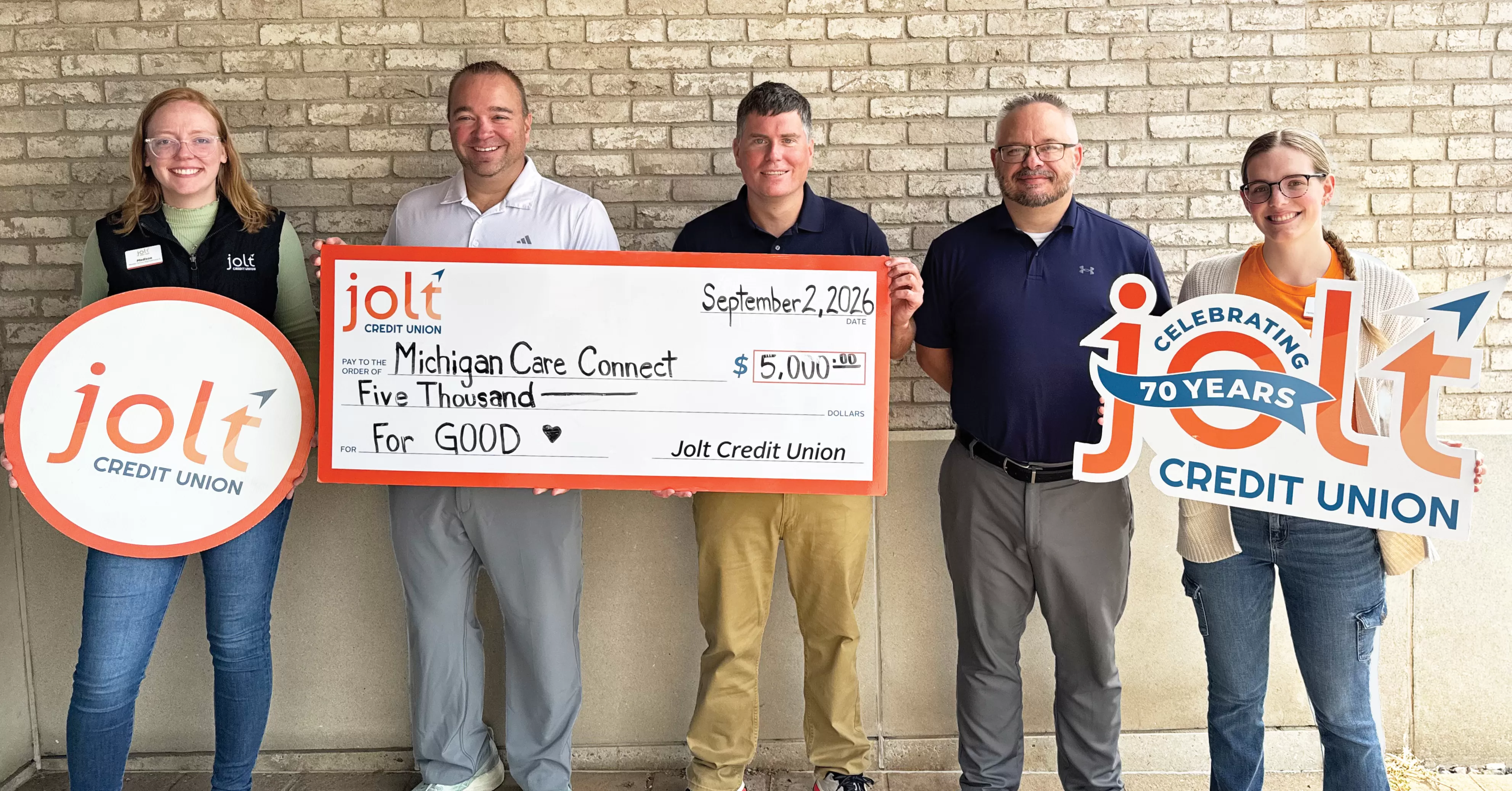 Jolt Credit Union employees presenting a $5,000 check to Michigan Care Connect as part of Jolt's 