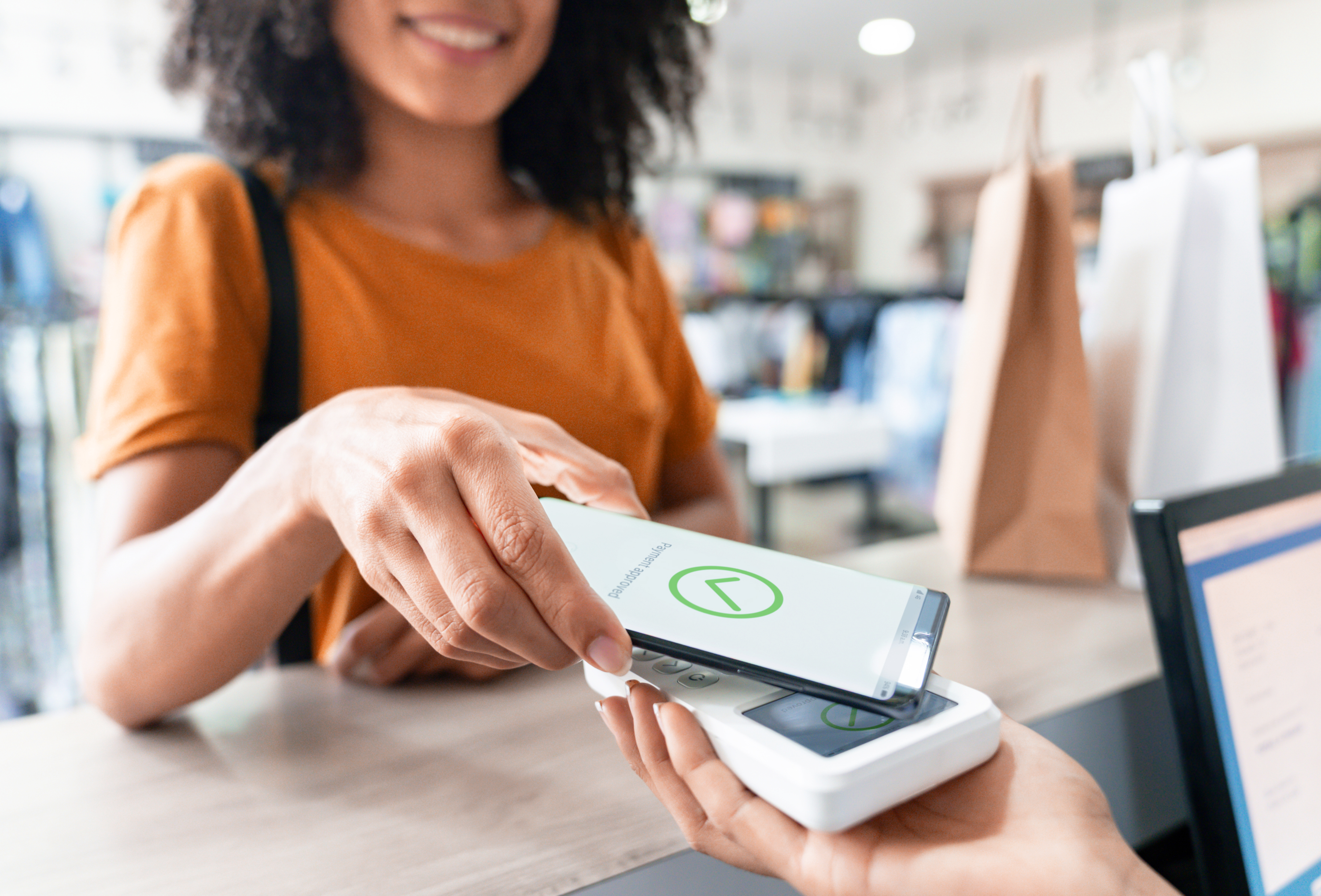 women paying with cell phone contactless