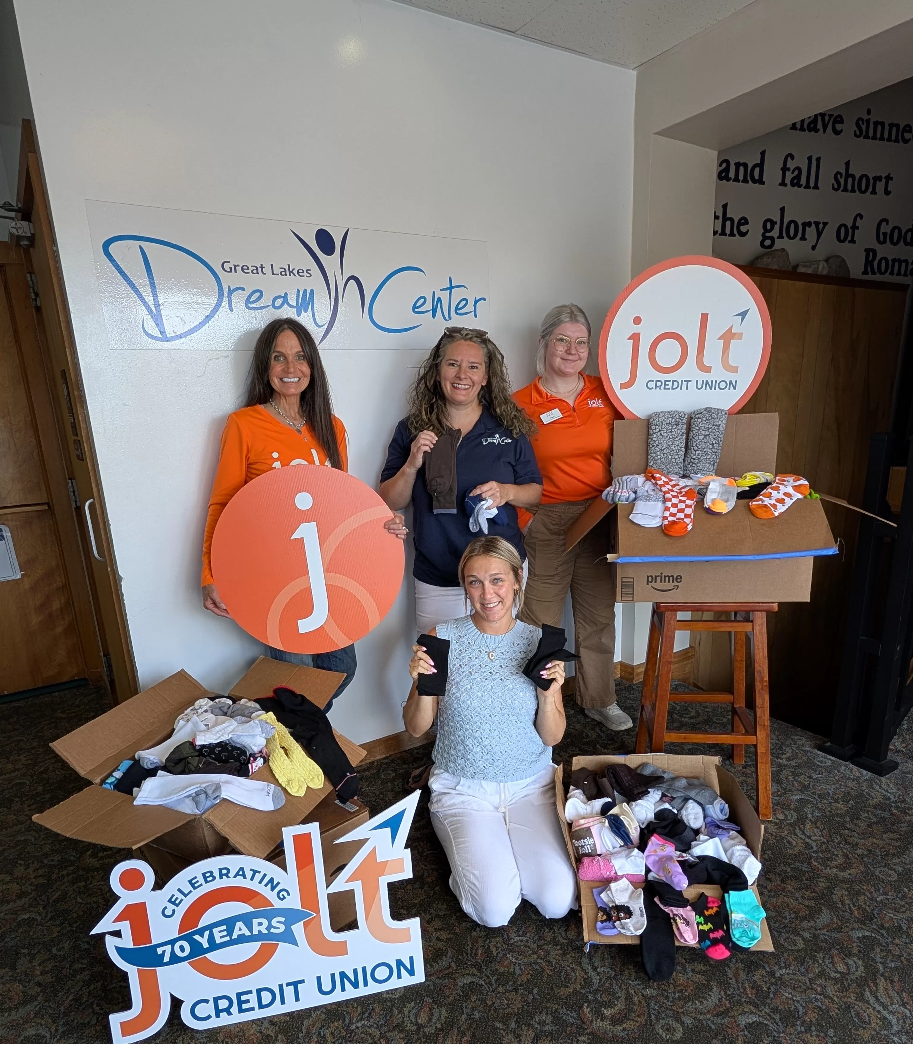 Jolt Credit Union Employees presenting socks from their member sock drive to the Great Lakes Dream Center